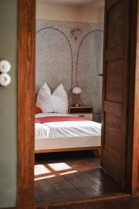 a bedroom with a bed with red and white sheets at Pößnecker Werkstätten -Tessenow Wohnung in Pößneck