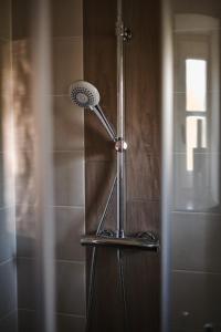 een douche met een douchekop in de badkamer bij Pößnecker Werkstätten -Tessenow Wohnung in Pößneck