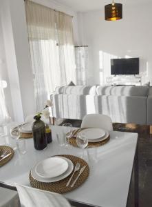 雅典的住宿－Gtrip P Faliro Coastal Comfort 4F，一张带盘子和玻璃杯的白色桌子和一张沙发