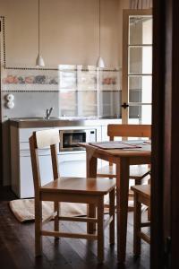 cocina con mesa, sillas y fregadero en Pößnecker Werkstätten -Tessenow Wohnung en Pößneck