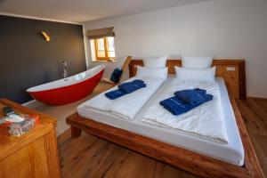 um quarto com uma banheira e uma cama com blueippers em Alpenloft 2 em Mittenwald