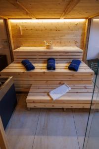 uma sauna de madeira com almofadas azuis e um avisor em Alpenloft 2 em Mittenwald