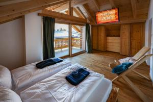 uma sala de estar com duas camas e uma televisão em Alpenloft 2 em Mittenwald