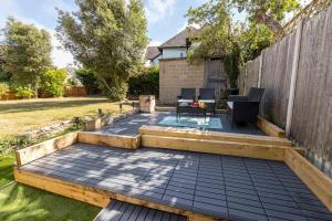 a backyard with a deck and a fence at Modern flat, sleeps 4, close to beach,Parking,WiFi - Queens Park Views in Bournemouth