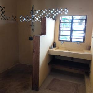 La salle de bains est pourvue d'un lavabo et d'une fenêtre. dans l'établissement Picalélouba, à Nosy Komba