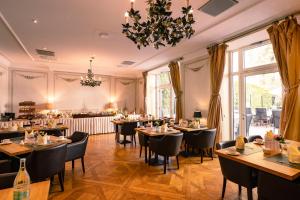 a restaurant with tables and chairs and a chandelier at Louisa's Place in Berlin