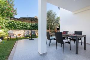 a patio with a table and chairs and an umbrella at Villa Isabel in Playa de Muro