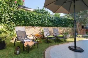 a group of chairs and a table with an umbrella at Villa Isabel in Playa de Muro