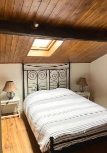 1 dormitorio con 1 cama grande y techo de madera en La Jousselinie en Saint-Auvent