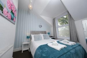 1 dormitorio con 1 cama con toallas en Hermosa Guest House en Scarborough