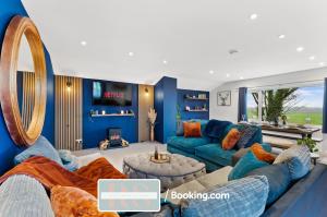 ein Wohnzimmer mit blauen Möbeln und einem großen Spiegel in der Unterkunft Two Bedroom Apartment By Rutland Stays Short Lets & Serviced Accommodation With Parking in Oakham