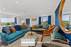 a living room with a blue couch and a mirror at Two Bedroom Apartment By Rutland Stays Short Lets & Serviced Accommodation With Parking in Oakham