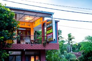 a building with a balcony with a sign on it at Tony's Garden House Back Packers inn in Jaffna