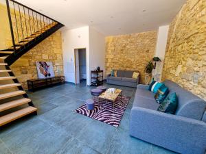 sala de estar con sofá azul y pared de piedra en Chateau Erigoye en Beychac-et-Caillau
