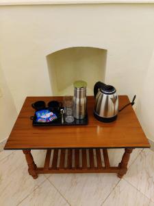 una mesa de madera con un set de té encima en BOB Haven01, en Ooty