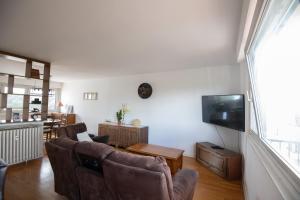 a living room with two chairs and a flat screen tv at Bel appartement entier, privé 5 Mn de Metz in Longeville-lès-Metz