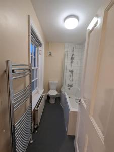 a bathroom with a tub and a toilet and a sink at Spacious & Budget Friendly 5 Bed Home! in Maidenhead