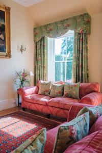 a living room with a red couch and a window at Mulberry House in Holbeton