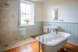 een badkamer met een bad en een wastafel bij Mulberry House in Holbeton