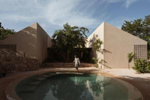 a woman standing in front of a house with a swimming pool at Galopina in Seyé