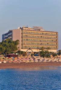 ein Hotel mit Liegestühlen und Sonnenschirmen am Strand in der Unterkunft Mediterranean Hotel in Rhodos (Stadt)
