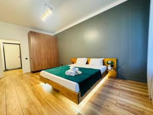 Infinity Estate Atameken في ألماتي: غرفة نوم مع سرير مع دبتين عليه