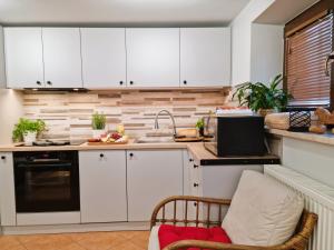 a kitchen with white cabinets and a sink at Gościniec Skorusa in Kościelisko