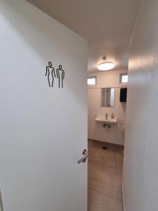 a bathroom with a door with two people on it at Slottets Anneks in Rønne