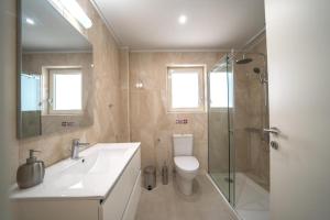 W łazience znajduje się umywalka, toaleta i prysznic. w obiekcie Alma City Center Apartment's w Heraklionie