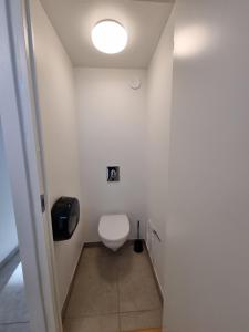 La salle de bains est pourvue de toilettes et d'une lumière au plafond. dans l'établissement Slottets Anneks, à Rønne