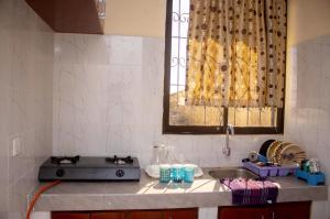 a kitchen counter with a sink and a window at At's Apartment in Mombasa