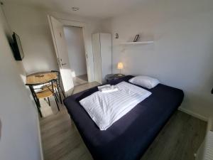 伦讷Slottets Anneks的一间带床和桌子的小卧室