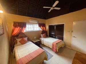 um quarto com 2 camas e uma ventoinha de tecto em Peaceful Palms Montego Bay em Montego Bay