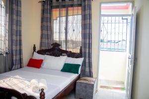 a bed in a room with a window and a bed sidx sidx sidx at At's Apartment in Mombasa
