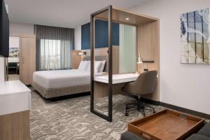 梅森SpringHill Suites by Marriott Cincinnati Mason的一间酒店房间，配有一张床和一张带镜子的书桌