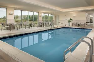 een zwembad in een hotel met tafels en stoelen bij SpringHill Suites by Marriott Cincinnati Mason in Mason