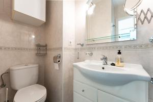 een badkamer met een toilet, een wastafel en een spiegel bij Estudio Hércules in Benalmádena
