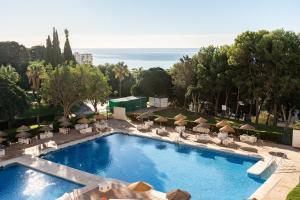 een zwembad met stoelen en parasols in een resort bij Estudio Hércules in Benalmádena