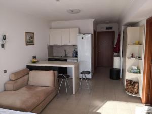 ein Wohnzimmer mit einem Sofa und einer Küche in der Unterkunft Emerald beach resort and spa , SATIN 705 , Macedonia Street 61, Nesebar Ravda 8238 , in Rawda