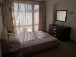 ein Schlafzimmer mit einem Bett, einer Kommode und einem Fenster in der Unterkunft Emerald beach resort and spa , SATIN 705 , Macedonia Street 61, Nesebar Ravda 8238 , in Rawda