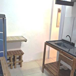 baño con lavabo y banco de madera en Tiny House da Tata en Florianópolis