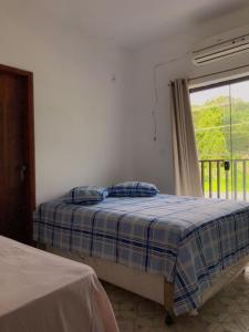 a bedroom with two beds and a window at CASA PARA VISITANTES E ROMARIAS DA NOSSA SRA. DE APARECIDA in Aparecida