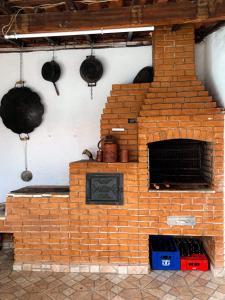 um forno de tijolo numa cozinha com panelas e frigideiras em CASA PARA VISITANTES E ROMARIAS DA NOSSA SRA. DE APARECIDA em Aparecida