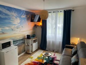 a living room with a couch and a painting of the ocean at Chambre Privée chez L' Habitant in Trignac