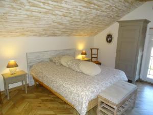 a bedroom with a bed and two tables and two lamps at Le Clos des Lavandes in Ruffey-lès-Beaune