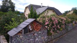 una pequeña casa en una pared de piedra con flores en Plain pied au vert, en Oloron-Sainte-Marie