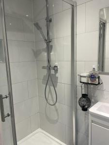 La salle de bains est pourvue d'une douche avec une porte en verre. dans l'établissement Cozy private room, à Londres
