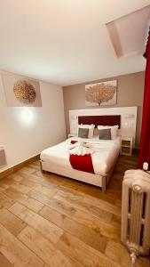 a bedroom with a large white bed and wooden floors at Pavillon Opéra Lafayette in Paris