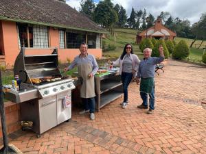 un grupo de personas parados frente a una parrilla en Portón de Ovejas SISGA para 24 personas, en Chocontá