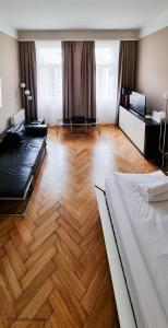 Großes Zimmer mit einem Bett und Holzboden in der Unterkunft Appartement Cervantes 13 in Wien